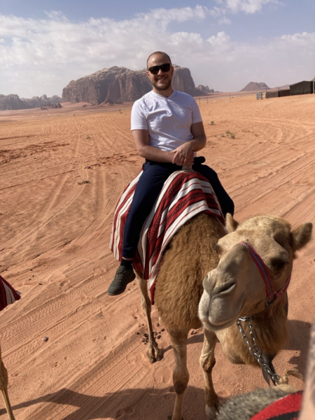 Jared Colston, Data Enterprise Manager for SSTAR Lab, rides a camel in Jordan.